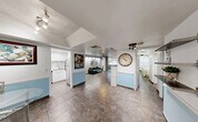 Located at 3710 Inverrary Dr in Lauderhill, FL, this single-floor residence offers a thoughtfully arranged layout comprising one bedroom, two bathrooms, a living room, dining room, kitchen, hallway, utility room, balcony, and three closets. Large-format tile flooring flows throughout the open main area, connecting the kitchen, dining, and living spaces seamlessly. The kitchen features stainless steel appliances, white cabinetry, a mosaic tile backsplash, and light stone countertops, delivering a clean and functional workspace. The living room is anchored by a ceiling fan and sliding glass doors that open to a private balcony with outdoor views, filling the space with natural light. Built-in shelving and a dedicated desk area provide a versatile workspace within the living room. The bedroom is comfortably sized, featuring a ceiling fan, natural light from a large window, recessed accent lighting, and ample closet storage. The two bathrooms offer distinct aesthetics: one is tiled in rich green marble-style tile with a tub-shower combo, while the second features bold, dark decorative wallpaper with an elegant pedestal sink. A dedicated utility room adds practical functionality to the overall layout.