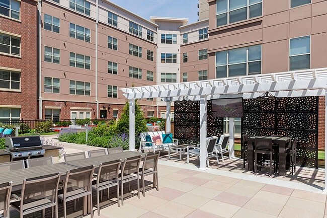 Entertain at the outdoor lounge complete with TVs, grilling station and dining areas - Malden Square Apartments