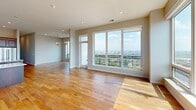 Located along University Avenue SE in Minneapolis, this expansive 2-bedroom, 5-bathroom residence offers a thoughtfully designed single-floor layout with generous living space throughout. The open-concept living room is anchored by a striking marble-surround fireplace and floor-to-ceiling windows that flood the space with natural light and frame sweeping panoramic views of the Minneapolis skyline and Mississippi River corridor. Warm hardwood flooring flows seamlessly through the living and kitchen areas.

The gourmet kitchen is outfitted with rich dark cabinetry, quartz countertops, a large center island, a secondary prep island, stainless steel appliances, and a sleek hood vent — ideal for both everyday living and entertaining. The dedicated laundry room features a stacked Whirlpool washer/dryer and ample dark wood cabinetry for storage.

The primary bedroom is generously sized, bathed in natural light, and enjoys elevated city views. Its spa-inspired en-suite bathroom showcases floor-to-ceiling Calacatta marble tile, a glass-enclosed walk-in shower with mosaic tile flooring, and polished chrome fixtures. Both bedrooms are served by well-appointed walk-in closets with custom built-in shelving and drawers. Additional bedrooms feature plush carpeting and large windows with scenic views, completing this refined urban residence.