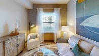 This 560 square foot apartment in Fort Myers, FL, showcases a thoughtful blend of modern design and efficient space utilization. The single-bedroom layout is complemented by two bathrooms, offering convenience and privacy. The heart of the home is an open-concept living area, where textured accent walls add depth and visual interest. Large windows, adorned with sheer curtains, flood the space with natural light, creating an airy ambiance.

The kitchen boasts sleek, wood-grain cabinetry, stainless steel appliances, and a central island, perfect for casual dining or food preparation. The bedroom features a soothing color palette with a striking accent wall and direct balcony access, extending the living space outdoors. Bathrooms are designed with clean lines, featuring modern fixtures and ample storage.

Throughout the apartment, wood-look flooring unifies the space, while carefully chosen furniture pieces maximize functionality without sacrificing style. Thoughtful lighting, including recessed ceiling lights and decorative lamps, enhances the overall atmosphere. The apartment's design prioritizes both aesthetics and practicality, resulting in a contemporary living space that feels much larger than its actual square footage.