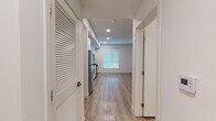 Located at 5401 Lankershim Blvd in North Hollywood, California, this single-floor unit offers a thoughtfully designed, modern living space with a clean, contemporary aesthetic throughout. Light-toned luxury vinyl plank flooring runs continuously across the entire unit, creating a cohesive and low-maintenance foundation that enhances the bright, airy feel of the interior.

The kitchen is a standout feature, outfitted with flat-front white cabinetry extending to the ceiling for ample storage, light gray quartz countertops, and a white subway tile backsplash. A full suite of stainless steel appliances includes a gas range, over-the-range microwave, dishwasher, and refrigerator, making this a highly functional space for cooking and entertaining.

A wide hallway connects the living areas, with louvered closet doors providing practical storage solutions. The open living area is bathed in natural light from a large window with blinds, offering a versatile, generously proportioned space with crisp white walls and recessed lighting overhead.

The bathroom is finished with a warm wood-toned vanity, light quartz countertop, a large frameless mirror, and a full tub-shower combination with white tile surround. The consistent use of light materials throughout the unit contributes to a calm, modern ambiance well-suited to the vibrant North Hollywood neighborhood.