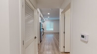 Located at 5401 Lankershim Blvd in North Hollywood, California, this single-floor unit offers a thoughtfully designed, modern living space with a clean, contemporary aesthetic throughout. Light-toned luxury vinyl plank flooring runs continuously across the entire unit, creating a cohesive and low-maintenance foundation that enhances the bright, airy feel of the interior.

The kitchen is a standout feature, outfitted with flat-front white cabinetry extending to the ceiling for ample storage, light gray quartz countertops, and a white subway tile backsplash. A full suite of stainless steel appliances includes a gas range, over-the-range microwave, dishwasher, and refrigerator, making this a highly functional space for cooking and entertaining.

A wide hallway connects the living areas, with louvered closet doors providing practical storage solutions. The open living area is bathed in natural light from a large window with blinds, offering a versatile, generously proportioned space with crisp white walls and recessed lighting overhead.

The bathroom is finished with a warm wood-toned vanity, light quartz countertop, a large frameless mirror, and a full tub-shower combination with white tile surround. The consistent use of light materials throughout the unit contributes to a calm, modern ambiance well-suited to the vibrant North Hollywood neighborhood.