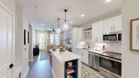 Located at 120 Whitby Lane in Birmingham, Alabama, this well-appointed one-bedroom, one-bathroom residence offers a smart, efficient layout across a single floor. The open-concept design connects the kitchen, living room, and hallway seamlessly, creating a cohesive and functional living environment.

The kitchen is a standout feature, outfitted with white shaker cabinetry, a subway tile backsplash, quartz countertops, stainless steel appliances — including a French door refrigerator, range, microwave, and dishwasher — and a central island with seating, illuminated by statement glass pendant lights.

The living room is bright and welcoming, featuring wood-look flooring, a ceiling fan, recessed lighting, and a glazed door that opens to a private balcony overlooking the resort-style pool and landscaped courtyard below.

The bedroom is a comfortable retreat with plush carpet, a ceiling fan, and windows that invite natural light. The full bathroom offers wood-look flooring, a marble-surround soaking tub and shower combination, a white vanity with a large mirror, and matte black hardware throughout.

The hallway connects all rooms efficiently, completing a residence that balances modern design with practical livability in a well-maintained community setting.