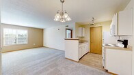 Located at 55 Eastpointe Ridge Drive in Columbus, Ohio, this single-floor residence offers four bedrooms and three bathrooms across a well-organized layout. The open-concept living and dining area is anchored by a decorative chandelier and flows seamlessly into the kitchen, which features a peninsula with a sink, white cabinetry, laminate countertops, and white appliances including a refrigerator, electric range, and built-in microwave. Track lighting illuminates the kitchen, while light wood-look flooring adds warmth to the space. The living area is carpeted and provides ample room for a variety of furniture arrangements. The bedrooms are carpeted and finished with neutral tones, offering clean, versatile spaces. One bedroom features a vaulted ceiling detail, adding architectural interest. The three bathrooms are functionally appointed — one includes a walk-in shower with sliding glass doors and wood-tone door accents, while another features a full soaking tub and shower combination. Throughout the home, warm beige and cream tones create a cohesive, inviting atmosphere. Two hallways connect the rooms efficiently, and a dedicated closet provides additional storage. Natural light enters through windows with blinds in select rooms, contributing to the home's bright and comfortable feel.