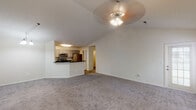 Located at 1550 Waterford Lane in Tuscaloosa, Alabama, this single-floor residence offers a well-designed layout with a variety of functional and comfortable spaces throughout.

The main living area is a standout feature, showcasing soaring vaulted ceilings and soft carpeted flooring. A ceiling fan with a light fixture is centrally positioned, enhancing airflow and ambiance. The open layout connects seamlessly to the kitchen, which is accessible via a breakfast bar-style peninsula with dark countertops. The kitchen is equipped with stainless steel appliances, including a range, over-the-range microwave, and refrigerator, complemented by gray cabinetry and wood-look flooring.

Additional rooms include generously sized bedrooms with carpeted floors, vaulted or standard ceilings, and ceiling fans. Natural light enters through windows dressed with blinds and curtains. The bathrooms feature dark granite-style countertops, gray cabinetry, a soaking tub, a tub-shower combination, and wood-look flooring.

An attached garage with a concrete floor provides secure parking and interior access via a carpeted staircase with a white handrail. Throughout the home, neutral tones and clean finishes contribute to a bright, move-in-ready atmosphere.