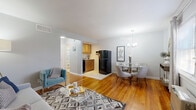 Located at 1 Chester Cir in New Brunswick, NJ, this one-bedroom, one-bathroom unit offers a well-organized single-floor layout that maximizes every square foot. Rich hardwood floors run throughout the main living areas, lending warmth and continuity to the space.

The living room welcomes residents upon entry, providing a comfortable area bathed in natural light from a large window dressed with floor-length curtains. It flows seamlessly into the dedicated dining area, which is accented by a stylish chandelier overhead, creating an inviting atmosphere for meals and gatherings. Adjacent to the dining space, the kitchen features warm wood cabinetry, black appliances including a full-size refrigerator, and tile flooring — efficiently equipped for everyday cooking needs.

The bedroom is a calm, well-lit retreat with a ceiling fan, a natural-light window with blinds, and access to multiple closets — three in total throughout the unit — offering generous storage. The bathroom includes a tiled tub/shower combination, a wood-cabinet vanity with a white countertop sink, and a small window for ventilation. A hallway connects the main rooms, adding to the functional flow of the layout. Neutral gray walls throughout create a clean, cohesive aesthetic well-suited for a variety of personal styles.