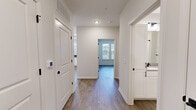 Located at 510 McLean St in Belmont, NC, this well-appointed 2-bedroom, 2-bathroom unit offers a thoughtfully designed single-level layout with modern finishes throughout. Light wood-look flooring runs continuously across all rooms, creating a cohesive and clean aesthetic.

The kitchen serves as a central highlight, featuring white shaker cabinetry with matte black hardware, a dark tile backsplash, quartz countertops, stainless steel appliances, and a peninsula with pendant lighting overhead. A window above the sink brings in natural light, and the space flows naturally into the living area.

A wide hallway connects the bedrooms, bathrooms, and closets with ease. Both bedrooms are generously proportioned with large windows that invite abundant natural light. The primary bedroom includes access to a spacious walk-in closet outfitted with wire shelving systems and a dedicated en-suite bathroom. This bathroom features a dual-sink vanity with white cabinetry, matte black fixtures, a large mirror, and a glass-enclosed shower.

The second bedroom also benefits from multiple windows and a ceiling fan. A second full bathroom serves the remainder of the unit. Clean white walls, recessed lighting, and panel-style doors complete the modern, move-in-ready atmosphere throughout.