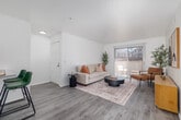 This thoughtfully designed 1-bedroom, 1-bathroom home offers a bright and cohesive interior defined by a neutral color palette, light wood-style flooring, and clean white walls throughout. The open living area is spacious and inviting, anchored by a sliding glass door that fills the room with natural light and provides access to an outdoor balcony. The space flows seamlessly into a dining area and a well-equipped kitchen featuring white cabinetry, gray laminate countertops, stainless steel appliances including a range and refrigerator, an under-cabinet range hood, and a convenient breakfast bar with seating — ideal for casual dining or entertaining. A dedicated dining nook adjacent to the kitchen adds further versatility. The bedroom is a calm retreat with a large sliding closet, a window providing natural light, and ample space for furnishings. An additional room with a window and closet serves well as a home office or flex space. The bathroom includes a full tub-shower combination. Multiple closets throughout provide generous storage. Textured ceilings and visible HVAC vents reflect a practical residential design, while the overall light-toned aesthetic creates a clean, modern ambiance throughout.