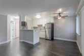 Located at 3670 Peacock Court in Santa Clara, CA, this one-bedroom, one-bathroom home offers an efficient and well-designed single-floor layout. The kitchen is a standout feature, showcasing white shaker cabinetry with crown molding, a mosaic tile backsplash, light quartz countertops, and a full suite of stainless steel appliances including a refrigerator, range, microwave, and dishwasher. A peninsula with breakfast bar seating extends into the living area, creating an open, connected feel. The living space features wood-look flooring, soft gray walls, and crown molding, with a ceiling fan providing comfort and airflow. The bedroom is carpeted for warmth and comfort, equipped with a ceiling fan and a wide window fitted with vertical blinds that allow for natural light. A dedicated closet provides convenient storage. The bathroom is neatly appointed with wood-look flooring, a tub-shower combination enclosed by sliding glass doors, a toilet, and a wall-mounted storage cabinet. Clean white trim and a cohesive neutral color palette carry throughout the home, lending a fresh and modern aesthetic to this efficiently designed Santa Clara residence.