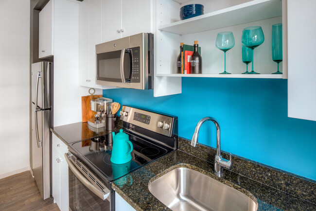 Kitchen with white cabinetry, granite countertops, stainless steel appliances and hard surface flooring - AVA Wheaton