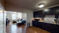 This single-floor unit offers four bedrooms and two bathrooms across a well-designed, functional layout. The kitchen is outfitted with dark espresso cabinetry, granite-style countertops, a double-basin sink, and a full suite of black appliances including a range, microwave, dishwasher, and refrigerator. Hardwood-style flooring flows through the kitchen and connects seamlessly into the living area via an open archway passage.

The living room is generously proportioned, featuring multiple windows that allow natural light to fill the space, along with a ceiling fan overhead. A dedicated dining area is situated adjacent to the living room, providing a practical layout for everyday living and entertaining.

The four bedrooms are carpeted for comfort, each offering window access for natural light and ceiling fans in select rooms. The primary bathroom features a double-sink vanity with dark cabinetry, a large mirror, and a shower-tub combination. The second bathroom offers a single-sink vanity and a shower-tub combo, finished with tile flooring. Neutral wall tones and consistent finishes throughout the unit create a cohesive, understated aesthetic well-suited for comfortable day-to-day living.