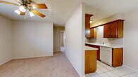Located at 1420 NW Hunter Rd in Lawton, Oklahoma, this one-bedroom, one-bathroom unit offers a practical and well-organized single-floor layout. The combined living, dining, and kitchen area forms the heart of the home, with soft carpet underfoot in the living and dining spaces, complemented by a ceiling fan overhead. A half-wall partition separates the living area from the kitchen, which features a classic galley design lined with warm oak cabinetry on both sides, a tile backsplash, light countertops, tile flooring, and a full suite of appliances including a range, microwave, refrigerator, and dishwasher. The bedroom is a comfortable, carpeted room with a ceiling fan and a window that brings in natural light, offering a quiet retreat. Three closets throughout the unit provide generous storage options. The bathroom is clean and functional, featuring tile flooring, a tub-shower combination with white tile surround, a toilet, and a vanity with overhead cabinetry for additional storage. Neutral tones and textured ceilings are consistent throughout, giving the space a cohesive and move-in-ready feel. This unit delivers efficient use of space with all essential amenities in a straightforward layout.