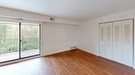 Located at 1100 Albert Rd in Brookhaven, PA, this well-appointed 2-bedroom, 2-bathroom unit is thoughtfully laid out across a single floor. Warm hardwood-style flooring runs throughout the living areas and bedrooms, lending a cohesive and inviting feel to the space. The combined kitchen and living room area serves as the heart of the unit, with the kitchen featuring rich wood cabinetry, light countertops, a subway tile backsplash, and a full suite of white appliances including a range, over-the-range microwave, and dishwasher. The open living area is bright and airy, with a sliding glass door that leads to a private balcony overlooking lush, tree-lined greenery. The spacious primary bedroom benefits from natural light through multiple windows and includes a louvered closet. The second bedroom is also well-sized with its own closet and window views. The two bathrooms offer distinct finishes — one features a marble-top vanity with a rich wood cabinet base and Hollywood-style lighting, while the second includes tiled walls and a safety grab bar. The unit includes a dedicated closet for additional storage. Clean white walls and neutral tones throughout create a bright, move-in-ready environment.