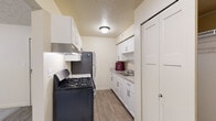 This single-story, 2-bedroom, 1-bathroom unit in Elkhart, Indiana offers a practical and efficiently designed layout. The galley-style kitchen features white cabinetry, light granite-style countertops, wood-look vinyl flooring, a gas range, and a stainless steel refrigerator, providing functional workspace along both walls. Upper and lower cabinet storage is plentiful given the kitchen's compact footprint.

Both bedrooms are carpeted and finished with neutral, light-toned walls and textured ceilings. Each room includes a window overlooking greenery, allowing natural light to fill the space. The spacious primary bedroom includes a sliding-door closet with a hanging rod for organized storage, along with direct access to adjacent rooms. The second bedroom offers a similarly bright feel with a large window fitted with vertical blinds.

The full bathroom is finished with wood-look tile flooring, a white vanity with a granite-style countertop, and a full-size soaking tub with an overhead shower and clean white surround panels. Throughout the unit, neutral paint tones, textured ceilings, and consistent flooring materials create a cohesive, clean aesthetic well-suited for comfortable everyday living.