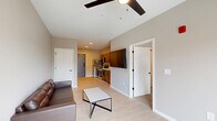 Located at 353 Vine St in West Lafayette, Indiana, this 1-bedroom, 1-bathroom unit offers a well-designed, contemporary living space with a thoughtful open-concept layout. Light wood-tone flooring runs throughout the main living area, creating a clean and cohesive aesthetic.

The kitchen and living room share an open, connected footprint. The kitchen is outfitted with warm wood cabinetry featuring matte black hardware, bright white quartz countertops, a stainless steel undermount sink with a matte black pull-down faucet, and stainless steel appliances including a dishwasher. The adjacent living room is bright and airy, highlighted by a ceiling fan, neutral taupe walls, and a sliding glass door that opens to a private balcony with outdoor views.

The bedroom features plush carpeting, a window with blinds allowing natural light, and a ceiling fan. It connects directly to the full bathroom, which includes a soaking tub and warm wood vanity cabinetry with matching matte black hardware. Two closets provide ample storage, including a walk-in closet equipped with wire shelving and carpeted flooring.

The unit presents a modern, clean design with consistent finishes throughout, making it a functional and stylish living space in the West Lafayette area.