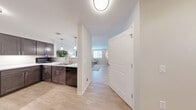 Located at 400 Willis Avenue in Rochelle, Illinois, this single-floor unit offers a well-designed layout that maximizes functionality and comfort. Light wood-tone flooring runs throughout, lending warmth and visual continuity to the entire space.

The open-concept kitchen and living area form the heart of the unit. The kitchen is outfitted with rich dark brown shaker-style cabinetry, light quartz countertops, black appliances including a range and refrigerator, and a stainless steel sink beneath pendant lighting. A breakfast bar with barstool seating creates a seamless transition into the living area, which is bright and airy thanks to a large window that invites natural light. The living space provides a comfortable setting for relaxing or entertaining.

The bathroom is clean and well-appointed, featuring a dark wood vanity with a white countertop, a framed mirror with brushed nickel lighting, and a full tub/shower combination with accessibility grab bars. A dedicated closet rounds out the unit, offering practical storage.

Throughout, the space is defined by a neutral color palette of whites and soft grays, modern hardware finishes, and a cohesive design sensibility that balances style with everyday practicality.