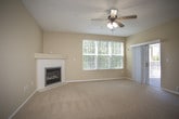 This single-floor residence offers a thoughtfully designed layout that balances comfort and functionality. The spacious living room serves as the heart of the home, featuring plush wall-to-wall carpeting, a ceiling fan with integrated lighting, a classic fireplace, and large windows that invite an abundance of natural light. A sliding glass door leads to an outdoor area, further enhancing the sense of openness. Adjacent to the living room, a pass-through breakfast bar connects to the kitchen, creating a seamless flow between spaces.

The galley-style kitchen is outfitted with warm honey-toned wood cabinetry, light stone countertops, and durable ceramic tile flooring. Black appliances — including a refrigerator, dishwasher, and range — provide a clean contrast to the cabinetry, while ample counter and storage space make it a practical and efficient workspace.

The bedroom is generously sized, finished with soft carpeting and a large window fitted with blinds, allowing for flexible light control and a pleasant outdoor view. Neutral warm-toned walls throughout the residence create a calm, cohesive aesthetic.

The bathroom features tile flooring, white cabinetry with overhead storage, a dark-toned countertop with an undermount sink, and a shower-tub combination, providing all essential amenities in a clean, organized layout.