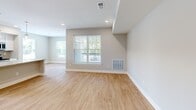 Located at 1600 New Britain Ave in Farmington, CT, this well-appointed 2-bedroom, 2-bathroom residence offers a thoughtfully designed single-floor layout with a comfortable, modern aesthetic. The open-concept kitchen and living area serves as the heart of the home, showcasing white shaker cabinetry, granite countertops with subtle veining, a large center island with pendant lighting, and a full suite of stainless steel appliances including a range, microwave, dishwasher, and refrigerator. A subway tile backsplash and recessed lighting complete the kitchen's clean, contemporary look. Warm hardwood-style flooring flows seamlessly throughout the main living areas and bedrooms, lending a cohesive and inviting feel. The spacious primary bedroom features a generous walk-in closet outfitted with wire shelving and hanging rods, providing ample storage. Both bathrooms are finished with large-format tile flooring, dark espresso vanities with white countertops, and brushed nickel fixtures. Each bedroom benefits from oversized windows with views of the surrounding landscape, filling the rooms with abundant natural light. A hallway connects all areas efficiently, and two dedicated closets add practical storage throughout this well-organized residence.
