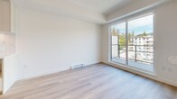 Located at 902 Lytton St in North Vancouver, BC, this well-designed one-bedroom, one-bathroom unit offers a clean, contemporary aesthetic throughout. Light oak-toned laminate flooring runs seamlessly across the entire space, complementing the bright white walls and creating a cohesive, modern feel.

The open-concept kitchen and living area forms the heart of the unit. The kitchen is outfitted with light wood cabinetry, a striking marble-effect tile backsplash, stainless steel appliances including a full-size refrigerator, dishwasher, and electric range, and ample upper and lower storage. Track lighting overhead ensures the kitchen is well-lit at all hours.

The living area flows naturally from the kitchen and features a large sliding glass door that opens to a private balcony, allowing abundant natural light to fill the space and offering views of the surrounding trees and neighbouring buildings.

The bedroom is a calm, well-proportioned retreat featuring a wide window with mountain and treetop views, a dedicated closet, and a baseboard heater. It connects conveniently to the full bathroom, which is finished with large-format grey stone-look floor tiles, a soaker tub, a vanity with storage, and clean white walls with recessed lighting. The overall ambiance of the unit is bright, minimalist, and move-in ready.