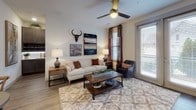 Located at 145 Legends Club Lane in Franklin, Tennessee, this single-floor residence offers a thoughtfully designed interior with a cohesive contemporary aesthetic throughout. The open-concept kitchen is a standout feature, outfitted with dark espresso cabinetry extending to the ceiling, a classic subway tile backsplash with under-cabinet lighting, stainless steel appliances, and light quartz countertops. A peninsula with seating for two, illuminated by modern pendant lights, connects the kitchen to the living and dining areas seamlessly. Wood-look flooring runs throughout the main living spaces, adding warmth and continuity.

The living room is comfortable and bright, benefiting from large windows and a glass door that invite natural light and outdoor views. A ceiling fan adds a practical touch to the welcoming atmosphere. Each bedroom is carpeted and features its own distinct character—one showcases bold abstract artwork above the bed, while another enjoys multiple windows with patterned drapery and ample natural light. The bathrooms are finished with dark vanity cabinetry, quartz countertops, large mirrors, and wood-look tile flooring, with direct access to well-organized walk-in closets equipped with built-in shelving.
