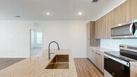 Located in Saint Augustine, FL, this well-appointed 2-bedroom, 2-bathroom residence offers a thoughtfully designed single-floor layout with modern finishes throughout. The open-concept kitchen and living area serves as the heart of the home, featuring warm wood-tone cabinetry, granite countertops, a central island with a sink, stainless steel appliances, and a clean white tile backsplash. Recessed lighting and durable wood-look flooring add to the contemporary aesthetic. The living area is bright and airy, benefiting from natural light through large windows and a glass door that opens to a private balcony with outdoor views. Ceiling fans are featured in the main living area and bedrooms for added comfort. Both bedrooms are carpeted and generously sized, with the primary bedroom offering two windows and ample natural light. The primary suite includes a spacious walk-in closet with wire shelving and an en-suite bathroom with a glass-enclosed walk-in shower, wood-tone cabinetry, and granite countertops. The second bathroom mirrors the modern design with a tub-shower combo, wood-tone cabinetry, and granite countertops. A hallway connects all rooms, ensuring a functional and cohesive floor plan throughout.