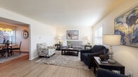 Located at 54 Nogoso Cir in Riverside, Ohio, this two-story home offers a thoughtfully designed layout across two levels. The living room is bright and welcoming, featuring warm wood-look flooring, neutral walls, and ample space for comfortable seating arrangements. Natural light filters through windows with horizontal blinds, creating an airy atmosphere throughout.

The kitchen is well-appointed with rich dark wood cabinetry, light granite-style countertops, black appliances, and a double sink positioned beneath windows that overlook the exterior. Its U-shaped layout provides generous counter and storage space, making it highly functional for everyday use.

Adjacent to the kitchen, the dining area features wood-look flooring, a chandelier overhead, and direct access to the exterior via a side door, offering convenience and natural light.

The primary bedroom includes a ceiling fan, carpeted flooring, and access to a full bathroom featuring dark wood cabinetry, a lengthy vanity with a white countertop, and a shower-tub combination. An additional bedroom with carpeted floors provides comfortable secondary accommodations. A half bathroom with a single vanity and wood-look flooring serves the main living areas. The utility space houses a Rheem Classic water heater with washer and dryer hookups, adding practical functionality to the home.