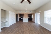 Located at 802 W Cherry Ln in Carlsbad, New Mexico, this single-story home offers a well-designed layout with modern finishes throughout. The open-concept living area features warm wood-look flooring and large windows that invite abundant natural light, along with a sliding glass door that opens to an outdoor patio, providing a seamless indoor-outdoor connection.

The kitchen is a standout space, equipped with rich dark cabinetry, light countertops, a central island with pendant lighting overhead, and black appliances including a range, microwave, and refrigerator. A stylish sliding barn door adds a contemporary touch and leads to an adjacent pantry or utility space. Recessed lighting illuminates the kitchen efficiently.

The bedrooms are carpeted for comfort and feature ceiling fans, ample natural light from multiple windows, and walk-in or reach-in closets with built-in shelving. One bedroom also includes a built-in open shelving unit alongside a double-door closet. The bathroom is finished with wood-look flooring, neutral wall tones, and a shower with a curtain enclosure. Throughout the home, clean white trim, neutral beige walls, and consistent flooring choices create a cohesive and inviting atmosphere.