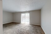 Located at 8828 M St in Omaha, Nebraska, this single-floor, 2-bedroom, 1-bathroom home offers a practical and comfortable layout across a well-utilized floor plan. The living room is a generous, open space featuring warm neutral-toned carpet, a textured ceiling, and a sliding glass door fitted with vertical blinds that opens to an outdoor patio, filling the room with natural light. The kitchen is well-appointed with white cabinetry, earthy countertops, tile flooring, a ceiling fan, and a full suite of appliances including a black refrigerator, white electric range, stainless steel dishwasher, and a built-in sink. A pantry closet adjacent to the kitchen provides additional storage. The spacious primary bedroom includes two open closets side by side, carpeted floors, and a textured ceiling. The second bedroom is a comfortable, carpeted room with a large window dressed in vertical blinds, offering natural light. The bathroom features a dark navy vanity with a white countertop, a large mirror with medicine cabinet, and tile flooring. A hallway connects all rooms efficiently, completing this clean, functional, single-story home.
