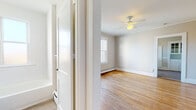 Located at 839 Farmington Ave in West Hartford, CT, this single-floor unit offers a clean, functional layout with classic charm throughout. Warm hardwood flooring runs through the main living areas and bedrooms, complemented by crown molding and neutral-toned walls that create a bright, welcoming ambiance.

The living spaces are generously proportioned, with multiple rooms featuring ceiling fans and baseboard heating, ensuring year-round comfort. Large double-hung windows invite abundant natural light and offer views of the surrounding neighborhood.

The kitchen is well-equipped with white cabinetry, a subway tile backsplash, laminate countertops, a gas range, and a window overlooking the outdoors. A charming built-in hutch with glass-panel upper cabinets adds a touch of character near the kitchen entry, providing additional storage and display space. Light vinyl plank flooring completes the kitchen area.

The full bathroom is finished in a clean, all-white palette featuring subway tile surrounding the bathtub and shower, a white vanity with chrome fixtures, a medicine cabinet mirror, and a privacy window that allows natural light while maintaining discretion.

The floor plan, as seen in the aerial model view, presents a straightforward and practical layout with well-defined spaces flowing logically from entry through to the living and sleeping areas, making efficient use of the available footprint.