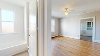 Located at 839 Farmington Ave in West Hartford, CT, this single-floor unit offers a clean, functional layout with classic charm throughout. Warm hardwood flooring runs through the main living areas and bedrooms, complemented by crown molding and neutral-toned walls that create a bright, welcoming ambiance.

The living spaces are generously proportioned, with multiple rooms featuring ceiling fans and baseboard heating, ensuring year-round comfort. Large double-hung windows invite abundant natural light and offer views of the surrounding neighborhood.

The kitchen is well-equipped with white cabinetry, a subway tile backsplash, laminate countertops, a gas range, and a window overlooking the outdoors. A charming built-in hutch with glass-panel upper cabinets adds a touch of character near the kitchen entry, providing additional storage and display space. Light vinyl plank flooring completes the kitchen area.

The full bathroom is finished in a clean, all-white palette featuring subway tile surrounding the bathtub and shower, a white vanity with chrome fixtures, a medicine cabinet mirror, and a privacy window that allows natural light while maintaining discretion.

The floor plan, as seen in the aerial model view, presents a straightforward and practical layout with well-defined spaces flowing logically from entry through to the living and sleeping areas, making efficient use of the available footprint.