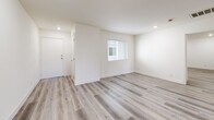 Located in the Los Angeles neighborhood of Glassell Park, this single-story residence offers three bedrooms and two full bathrooms within a thoughtfully designed floor plan. Light wood-tone luxury vinyl flooring runs consistently throughout the home, lending a cohesive, clean aesthetic to every room.

The kitchen is a standout feature, outfitted with white shaker-style cabinetry, gray countertops, and a full suite of stainless steel appliances, including a gas range, over-the-range microwave, and refrigerator. A window above the sink allows natural light to brighten the space. The adjacent living room is open and airy, with recessed lighting and a window providing additional daylight.

The primary bedroom is a comfortable size, featuring a sliding glass door that opens to a private balcony with outdoor views, along with recessed lighting. The additional bedrooms are bright and well-proportioned, one featuring a mirrored sliding closet. Both bathrooms are finished in white tile with tub-shower combinations, white cabinetry, and gray countertops, maintaining the home's clean, modern palette throughout.