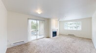 This single-floor, 3-bedroom, 2-bathroom home offers a comfortable and practical layout across a well-utilized floor plan. The open living room serves as the heart of the home, featuring plush carpeting, a tile-surround fireplace, and sliding glass doors that open to a balcony with views of mature trees, filling the space with natural light alongside an additional picture window. The kitchen is efficiently designed with warm wood cabinetry, ample counter space, a double-basin sink, tile flooring, and a full suite of white appliances, including a refrigerator, range, and dishwasher. Track lighting and a window above the sink add brightness to the workspace. The primary bedroom offers generous proportions with soft carpet and direct access to a private bathroom featuring a wood-toned vanity, tile flooring, a soaking tub, and a spacious walk-in closet outfitted with wire shelving. The additional bedrooms are carpeted and each include closet storage. A carpeted hallway connects the private areas of the home, with a second bathroom conveniently accessible. A dedicated laundry room with tile flooring accommodates a full-size washer and dryer, adding everyday convenience to this well-rounded home.