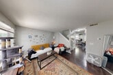 This multi-story home in East Lansing, Michigan offers four bedrooms and five bathrooms spread across three well-organized floors. The main level features a welcoming living room with dark hardwood flooring, a textured ceiling, and windows that bring in natural light. A staircase connects seamlessly to the combined dining and kitchen area, which is equipped with white shaker-style cabinetry, granite countertops, stainless steel appliances including a gas range and French door refrigerator, recessed lighting, and rich hardwood floors throughout. The upper floors house the four bedrooms, each carpeted and featuring closets, windows, and access to hallways. The primary bedroom offers a comfortable, private retreat. Five bathrooms are distributed throughout the home, each featuring clean, functional finishes including dark countertops and vanity mirrors. A dedicated laundry room adds everyday convenience. With six closets spread across all three floors, storage is abundant. Three staircases provide efficient access between levels, making this a highly functional layout suited for shared or family living in a convenient East Lansing location.