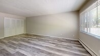 Located on Brewster Street in Saint Paul, MN, this one-bedroom, one-bathroom unit offers a well-organized single-floor layout designed for comfortable everyday living. The living room is a generous, open area featuring light gray luxury vinyl plank flooring, neutral beige walls, a textured ceiling, and a large window that allows natural light to fill the space. A wall-mounted air conditioning unit and baseboard heating provide year-round climate control. The bedroom is a well-proportioned room finished with plush carpeting, soft neutral walls, a textured ceiling, and a window with views of surrounding greenery. Baseboard heating keeps the room comfortable through Minnesota winters. The bathroom is cleanly finished with tile flooring, white cabinetry, a marble-style countertop with a single vanity sink, a large mirror with overhead lighting, and a tub-shower combination. Two closets provide practical storage throughout the unit. The overall aesthetic is clean, neutral, and move-in ready, making the space versatile for a range of furnishing styles. The unit's straightforward layout and functional features make it a practical and comfortable home in a residential Saint Paul neighborhood.