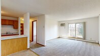 Located at 2488 Malmquist Ave in Red Wing, Minnesota, this one-bedroom, one-bathroom unit offers a practical and well-organized single-floor layout. The open living room is generously sized, featuring soft wall-to-wall carpeting, a textured ceiling, baseboard heating, a wall-mounted air conditioning unit, and a sliding glass door that fills the space with natural light and provides access to a private balcony with outdoor views.

The galley-style kitchen is efficiently designed with warm oak cabinetry offering ample storage, white appliances including a range, refrigerator, and dishwasher, light tile flooring, and a stainless steel sink. A pass-through counter connects the kitchen to the living area, creating an open feel between the two spaces.

The bedroom is a comfortable size, complete with plush carpeting, a wide sliding-door closet for storage, a window with blinds overlooking the surroundings, and baseboard heating. A textured ceiling ties the room's design together.

The full bathroom features tile flooring, a full-size soaking tub with shower, a wood-framed vanity with a white countertop, and a wall mirror. Clean white walls and fixtures give the bathroom a bright, functional aesthetic throughout.