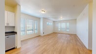 Located at 230 Lincoln St in Fairview, Oregon, this single-floor, 2-bedroom, 1-bathroom home offers a clean and contemporary design throughout. Light wood flooring runs continuously across the entire space, creating a warm, cohesive look that complements the bright white walls and neutral palette.

The open living room is generously proportioned, filled with natural light streaming through multiple windows fitted with slatted blinds. The space feels airy and open, offering views of the surrounding greenery.

The kitchen features white shaker-style cabinetry with brushed nickel hardware, gray countertops, a stainless steel sink, and a full suite of stainless steel appliances including a refrigerator, range, and microwave. It connects seamlessly to the living area.

Both bedrooms are well-sized and bright, each with large windows that invite natural light and outdoor views. The primary bedroom includes a walk-in closet with built-in storage and electrical panel access. The second bedroom is equally light-filled.

The bathroom is tastefully finished with white shaker vanity cabinetry, dark countertops, modern light fixtures, a large mirror, and a small privacy window. In-unit laundry hookups are also present, adding everyday convenience to this well-appointed home.