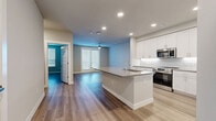 Located at 2332 N 7th St in Phoenix, Arizona, this thoughtfully designed one-bedroom, one-bathroom home offers a clean, modern aesthetic throughout its well-utilized single floor. Light-toned luxury vinyl plank flooring flows consistently through every room, creating a cohesive and contemporary feel.

The open-concept kitchen and living area serves as the heart of the home. The kitchen is outfitted with crisp white shaker cabinetry, a classic white subway tile backsplash, sleek gray quartz countertops, and a central island with sink — ideal for both meal prep and casual dining. Stainless steel appliances, including a French door refrigerator, range, microwave, and dishwasher, complete the space. Recessed lighting illuminates the area efficiently.

The living room flows naturally from the kitchen and features a ceiling fan, neutral wall tones, and French doors that bring in natural light. The spacious bedroom also includes a ceiling fan, window with blinds, and a modern paneled door. The bathroom is clean and functional, featuring white subway tile in the shower, a white vanity with gray countertop, and direct access to a well-organized walk-in closet with built-in shelving and hanging rods. The overall ambiance is bright, clean, and move-in ready.