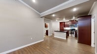 Located in Little Rock, AR, this single-floor, 2-bedroom, 2-bathroom residence offers a thoughtfully designed layout that balances comfort and style. The living room welcomes you with an elegant arched front entry door, crown molding, warm hardwood-style flooring, and a fireplace framed by a white marble-style surround and granite-tiled base — an eye-catching focal point. The space flows seamlessly into the open-concept kitchen, which is a standout feature of the home. Rich dark mahogany cabinetry reaches to the ceiling, complemented by dark granite countertops, a classic white subway tile backsplash, and a suite of stainless steel appliances including a refrigerator, range, and microwave. A central island with an undermount sink adds both functionality and additional prep space. The bedrooms are generously sized, each featuring ceiling fans, crown molding, hardwood-style flooring, and window blinds. The primary bedroom is a comfortable retreat with ample proportions. Both bathrooms echo the kitchen's design aesthetic with matching dark cabinetry and granite countertops. One bathroom features a soaking tub with tile surround, while the other includes a glass-enclosed shower, offering a spa-like experience. A dedicated closet completes the functional layout of this well-finished residence.