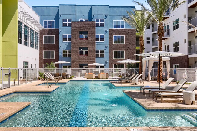 La terraza con piscina con la que siempre has soñado. Con tumbonas, sombrillas, una hoguera y fuentes de agua cristalinas, el patio de Garrett Uptown es el refugio perfecto para escapar del calor de Arizona. - Garrett Uptown Apartments