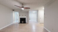 Located at 314 Spring Water Dr in Norcross, GA, this single-story home offers a well-organized layout with a variety of functional living spaces. The open living area serves as the heart of the home, highlighted by a white-mantled fireplace with a dark surround, light hardwood-style flooring, and a modern ceiling fan. The space flows openly into an adjacent area, creating a generous, connected feel throughout.

The kitchen features white cabinetry with contemporary hardware, white countertops, black appliances including an electric range, and light hardwood-style flooring. Bifold doors provide access to a utility or pantry area, adding practical storage. The kitchen's clean, neutral palette creates a bright and functional workspace.

The bedrooms are carpeted and well-sized, each equipped with ceiling fans and windows offering views of surrounding greenery. Closets with bifold doors and built-in shelving provide ample storage. One bedroom notably features a large window with abundant natural light.

The bathrooms are finished in neutral tones with gray vanity cabinetry, white countertops, large mirrors, and tile-style flooring. One bathroom includes a soaking tub and shower combination. Throughout the home, consistent neutral paint, clean white trim, and light flooring contribute to a cohesive, move-in-ready aesthetic.