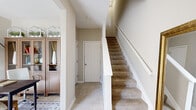 Located at 4115 Britton Pky in Hilliard, Ohio, this multi-level home spans three floors and offers a functional, well-organized layout. The entry level welcomes visitors with tile flooring, a carpeted staircase with white railings, and a warm hallway that sets the tone for the rest of the home.

The main living level features warm hardwood flooring throughout, including a bright living area with a staircase, and a kitchen equipped with dark cabinetry, light countertops, black appliances, and direct access to an outdoor area via a glass-paned door. Natural light flows in through multiple windows, creating an inviting atmosphere.

The upper floor houses the two bedrooms, including a generously sized primary bedroom featuring plush carpeting, multiple windows with sheer curtains, and a serene, light-filled ambiance. The second bedroom is equally well-appointed. Three bathrooms serve the home across its floors — one features a tub-shower combo, while another includes a glass-enclosed shower, both finished with clean tile flooring and neutral tones.

A dedicated office space provides a quiet work area, complete with built-in cabinetry. Two closets and a hallway round out the layout, ensuring practical storage throughout. The home's neutral color palette and consistent design language create a cohesive, comfortable living environment.