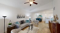 This single-floor residence features an open-concept layout where the living, dining, and kitchen areas flow seamlessly together, creating a cohesive and functional living environment. Throughout the main living spaces, wood-look flooring adds warmth and continuity, while ceiling fans provide both style and comfort.

The living room is generously proportioned, offering ample space for seating arrangements and accented by a ceiling fan overhead. Large windows near the front entry allow natural light to filter in. The space opens directly into the dining area, which is illuminated by pendant lighting, and transitions smoothly into the kitchen.

The kitchen is well-appointed with white shaker cabinetry, granite-style countertops, stainless steel appliances including a refrigerator, dishwasher, microwave, and range, plus pendant lights above the sink area that enhance the bright, clean aesthetic.

The bedroom is a comfortable, well-lit retreat with a ceiling fan and closet access. The bathroom features white cabinetry with granite countertops, wood-look flooring, and a walk-in marble-surround shower with glass enclosure. A spacious walk-in closet with built-in shelving and hanging rods provides excellent storage. An attached garage with an automatic opener completes this well-designed residence.