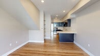 This two-story, 2-bedroom, 2-bathroom home in Reno, Nevada offers a thoughtfully designed layout spread across two floors. The main floor features an open-concept kitchen and living area with light hardwood-style flooring, recessed lighting, and a ceiling fan. The kitchen is a standout, boasting rich dark cabinetry, crisp white countertops with a curved breakfast bar, stainless steel appliances including a range, microwave, and dishwasher, and ample storage throughout. A sliding glass door from the living area opens to a private balcony, filling the space with natural light and views of the surrounding neighborhood. Both bathrooms are finished consistently with dark vanity cabinetry, light countertops, tile flooring, and well-lit mirrors. The bedrooms are carpeted and equipped with ceiling fans; the primary bedroom includes a spacious sliding-door closet. The upper floor features a charming room with vaulted, angled ceilings and warm hardwood-style flooring, adding architectural character. A second bedroom on this level enjoys natural light and neighborhood views. Neutral warm-toned walls throughout create a cohesive, calming ambiance, making this a well-balanced and functional home in the heart of Reno.