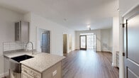 Located in Wake Forest, NC, this thoughtfully designed 2-bedroom, 2-bathroom residence offers a seamless blend of modern style and functional living across a single floor. The open-concept layout connects the kitchen, dining, and living areas, creating a bright and airy atmosphere enhanced by wood-style flooring and a large entry door that invites natural light. The kitchen is a standout feature, equipped with stainless steel appliances, granite countertops, a tile backsplash, gray shaker-style cabinetry, a wine rack, and track lighting overhead. A built-in desk with granite surface and open shelving adds a versatile workspace to the living area. The spacious primary bedroom includes a ceiling fan and access to a well-organized walk-in closet with wire shelving. The second bedroom also features a ceiling fan, plush carpeting, and large windows overlooking wooded scenery. Both bathrooms are finished with granite vanities and gray cabinetry; one includes a soaking tub with shower combo, while the other offers a glass-enclosed walk-in shower and an illuminated mirror. Three closets throughout the residence provide ample storage. Clean white walls and consistent finishes contribute to a cohesive, modern aesthetic throughout.