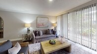 This single-story, two-bedroom, two-bathroom residence in Houston, TX offers a thoughtfully designed layout with consistent finishes throughout. The living room serves as the central gathering space, featuring crown molding, a textured ceiling, and floor-to-ceiling sliding glass doors that invite abundant natural light and provide views of the greenery outside. The open feel is enhanced by hardwood-style flooring that extends through the main living areas and bedrooms.

The kitchen is well-equipped with sage-green shaker cabinetry, dark granite countertops, a subway tile backsplash with under-cabinet lighting, and black appliances including a refrigerator, range, and dishwasher. A pass-through window connects the kitchen to the living space, improving the sense of openness.

Both bedrooms are comfortably sized, each featuring ceiling fans, hardwood-style flooring, and windows that allow natural light. The primary bedroom is paired with an en-suite bathroom, while the second bathroom features a tiled tub-shower combination, a gray vanity with marble-style countertop, and textured walls. A smart thermostat is also present, adding a modern convenience to this functional Houston residence.