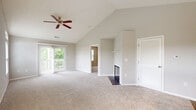 This two-bedroom, three-bathroom residence in Dayton, Ohio offers a thoughtfully designed single-floor layout with a range of standout architectural details. The living area impresses with vaulted ceilings, a ceiling fan, and soft carpeting, anchored by a classic fireplace that serves as the room's focal point. A sliding glass door opens to a private balcony overlooking lush greenery and a tranquil waterway, bringing natural light and scenic outdoor views into the living space.

The kitchen is efficiently laid out with white cabinetry, granite-style countertops, light hardwood-style flooring, and stainless steel appliances including a refrigerator, range, microwave, and dishwasher. Multiple windows allow natural light to fill the space. A peninsula counter connects the kitchen to the main living area.

The primary bedroom is generously sized with plush carpeting and access to an en-suite bathroom. Both bedrooms are served by well-appointed bathrooms featuring white vanities, bright lighting, and clean finishes. Four closets throughout the residence, including a spacious walk-in with wire shelving, provide ample storage. The entrance provides a welcoming transition into this comfortable and functional Dayton home.