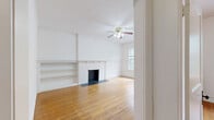Located on N Prospect Ave in Milwaukee's vibrant East Side neighborhood, this four-bedroom, single-floor home offers a generous layout filled with classic character. Warm hardwood floors run throughout the living areas and bedrooms, lending a timeless quality to the space. The two living rooms provide flexible use — one features a decorative cast-iron fireplace framed by a detailed mantel with built-in shelving, crown molding, a ceiling fan, and large windows that invite abundant natural light. The second living area offers an open, versatile space connected to the rest of the home. The kitchen is equipped with warm oak cabinetry, white tile backsplash, a gas range, full-size refrigerator, and a back door leading outside. Cast-iron radiators in several rooms provide classic radiant heat. The four bedrooms are bright and well-proportioned, with hardwood floors and natural light from windows throughout. The primary bedroom includes a dedicated closet. A hallway connects the rooms efficiently, and two closets provide practical storage. The overall ambiance is that of a well-preserved vintage home with traditional architectural details, offering spacious and functional living in a sought-after Milwaukee location.