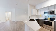Located at 2424 E TC Jester Blvd in Houston, TX, this single-story home offers five bedrooms and two bathrooms across a well-designed floor plan. The open-concept living, dining, and kitchen area serves as the heart of the home, where light hardwood-style flooring flows beneath a bright, airy layout. The kitchen is equipped with stainless steel appliances, white shaker cabinetry, subway tile backsplash, and a peninsula with a sleek white countertop and undermount sink — ideal for both cooking and casual dining. A pendant light anchors the dining area, which is framed by mirrored accents that amplify the natural light. The bedrooms feature plush carpeting and windows with blinds that allow in generous natural light, while the spacious primary bedroom includes elevated ceilings and a ceiling fan. The primary bathroom impresses with an L-shaped dual-sink vanity, gray cabinetry, white quartz countertops, and large framed mirrors. The second bathroom also features gray cabinetry, quartz countertops, and a tub-shower combo. A dedicated laundry area with an in-unit washer and dryer adds everyday convenience. A central hallway connects the bedrooms seamlessly, completing this functional and attractively finished Houston home.