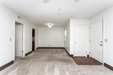 Located at 101–111 Castle Dr in Dothan, Alabama, this single-story unit offers a functional and straightforward layout across several well-defined spaces. The living area is generously sized, featuring neutral-toned carpet, dark baseboards, and a ceiling fan with integrated lighting. A set of vertical-blind-covered sliding glass doors provides access to an outdoor area while allowing natural light to fill the room.

The kitchen is a standout feature, equipped with rich dark wood cabinetry, light granite-style countertops, a mosaic tile backsplash, a black electric range, and hardwood-style flooring — offering a practical and visually appealing workspace.

The bedrooms are carpeted and bright, each fitted with ceiling fans and ample wall space. At least one bedroom includes a walk-in closet with built-in shelving, adding useful storage. Additional rooms provide flexible space with similar neutral finishes and ceiling fan lighting.

The bathroom features a full tub-shower combination with chrome fixtures and hardwood-style flooring, maintaining a clean, utilitarian aesthetic consistent throughout the unit. Dark baseboards and light walls create a cohesive visual theme across all rooms.