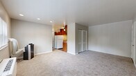 Located at 5466 Hamilton Ave in Cincinnati, Ohio, this single-floor, two-bedroom, one-bathroom home offers a practical and comfortable layout. The kitchen is a functional highlight, featuring warm medium-toned wood cabinetry extending to the upper walls, light stone-finish countertops, a double-basin sink, and white appliances including a refrigerator and electric range. Dark hardwood-style flooring grounds the kitchen, which flows into the adjoining living area with neutral carpet and a ceiling fan overhead.

Both bedrooms are finished with plush neutral carpet and painted in soft gray tones, lending a calm and understated atmosphere. The primary bedroom is generously proportioned, complete with a closet and direct access to the hallway. The second bedroom features white vertical paneling along one wall, windows that invite natural light, and baseboard heating. Additional windows in this room provide cross-ventilation and views to the outdoors.

The bathroom is efficiently designed, featuring a white vanity with cabinetry, a toilet, and a full tub-and-shower combination with classic white tile surround and a grab bar. A window above the tub brings in natural light, while mosaic tile flooring adds a distinctive decorative touch. Overall, this home presents a clean, move-in ready layout suited for comfortable everyday living.